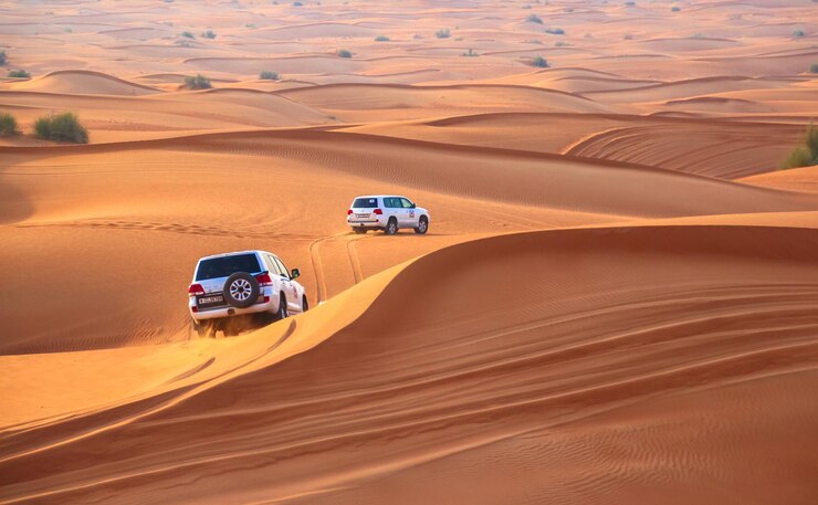 Jeep Safari Dubai adventure with 4x4 vehicles driving across golden sand dunes in the Arabian desert