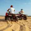 Self-Drive Dune Buggy Dubai adventure with riders enjoying an ATV ride across golden desert dunes.