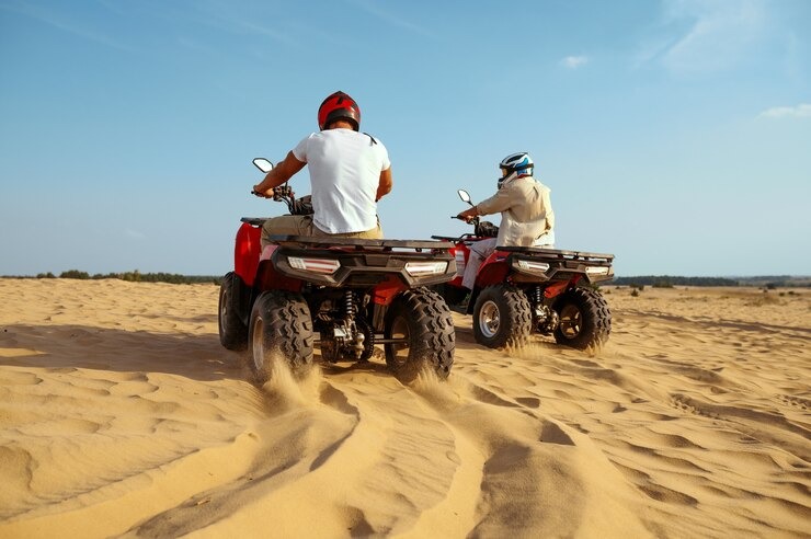Self-Drive Dune Buggy Dubai adventure with riders enjoying an ATV ride across golden desert dunes.